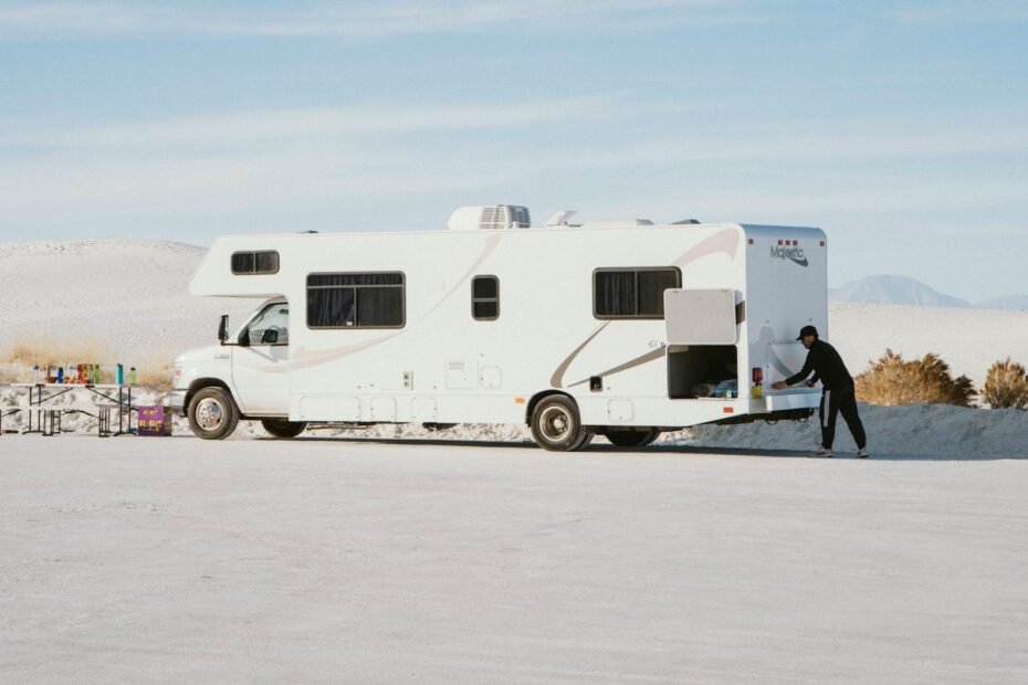 Side-by-side comparison of a motorhome and campervan parked at a scenic campsite illustrating the differences in size and design