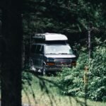 Motorhome vs Caravan: Which is Right for You? White motorhome and caravan parked side by side in UK countryside campsite for comparison