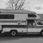 Three year old motorhome on dealer forecourt next to new model showing price comparison